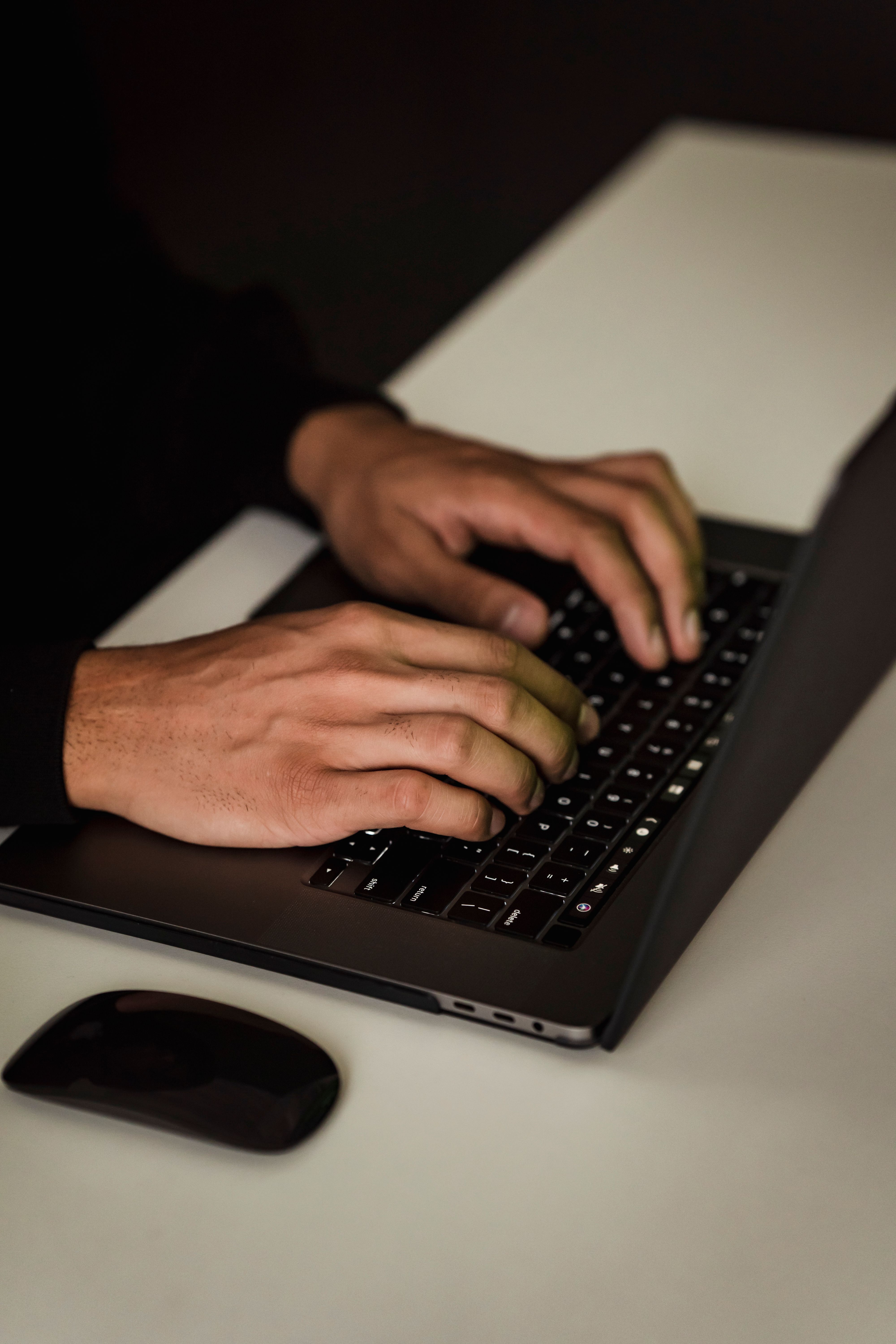 Manos trabajando en el teclado de un ordenador portátil